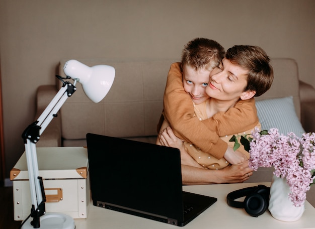 Ami gli abbracci funzionanti del computer portatile della mamma del figlio del bambino