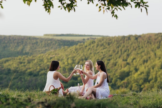 amiche che tintinnano bicchieri di vino bianco