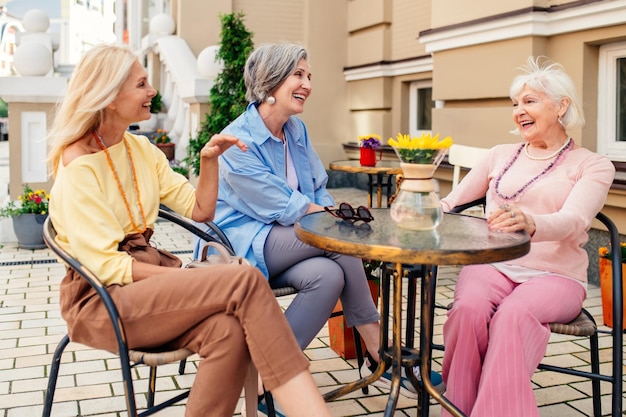 Amiche che usano lo smartphone mentre sono sedute al ristorante
