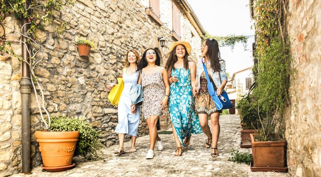 Amiche millenarie multirazziali che camminano nel tour della città vecchia