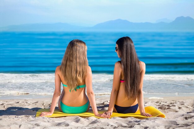 Amiche sedute sulla spiaggia.