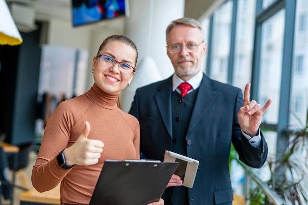 Amichevole uomo d'affari sorridente e imprenditrice mostrando il pollice in su Efficace negoziazione buon rapporto rendendo affare assunzione Foto di concetto di business