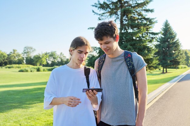 Amici adolescenti che parlano guardando lo schermo dello smartphone