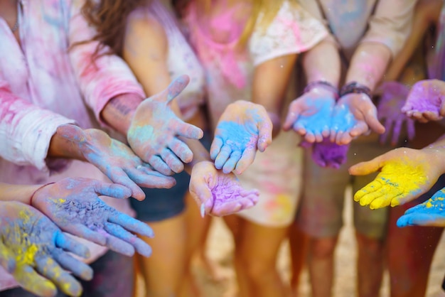 Amici adolescenti si divertono al festival di Holi festa in spiaggia celebrando le tradizionali vacanze di primavera indiane