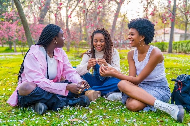 Amici africani che chiacchierano seduti in un parco in primavera