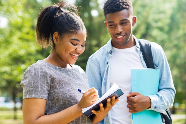 Amici afroamericani che condividono le conoscenze nel campus universitario in una giornata di sole all'aperto nel parco