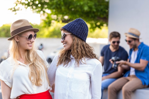 Amici alla moda con una conversazione divertente per le strade