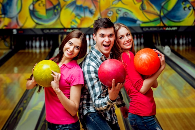 Amici allegri alla pista da bowling con le palle.