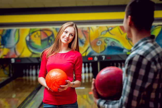 Amici allegri alla pista da bowling con le palle.