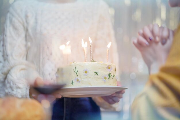 Amici allegri che si divertono a casa Festa di compleanno Sorella asiatica che beve vino rosso festeggiando con la torta di compleanno