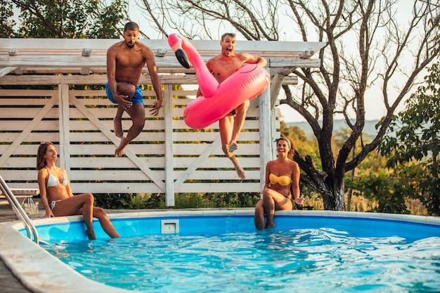 Amici allegri che si divertono in piscina