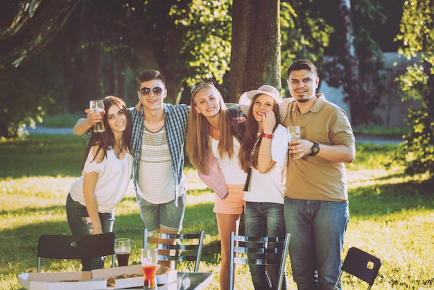 Amici allegri sul picnic nel parco. Mangiare la pizza