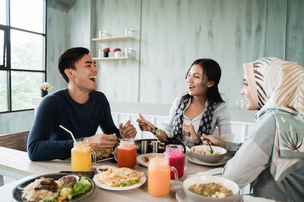 Amici asiatici felici pranzando insieme