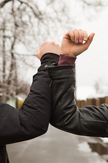 Amici che agitano i gomiti all'aperto. Le persone si salutano insieme con un nuovo stile per prevenire il coronavirus. Non stringere la mano. Stile di saluto al gomito.