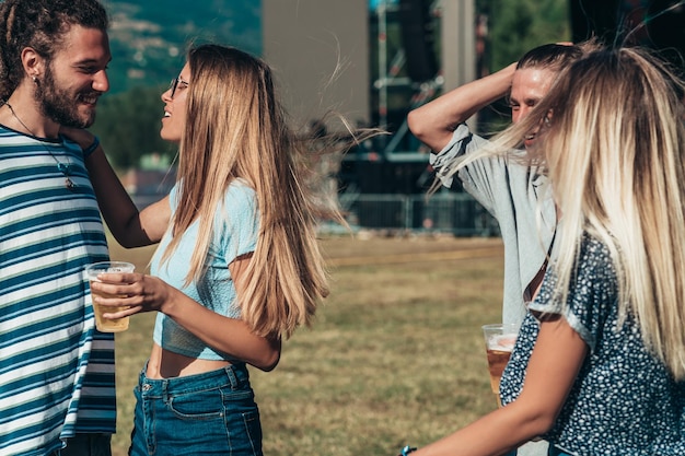 Amici che bevono birra e si divertono al festival musicale