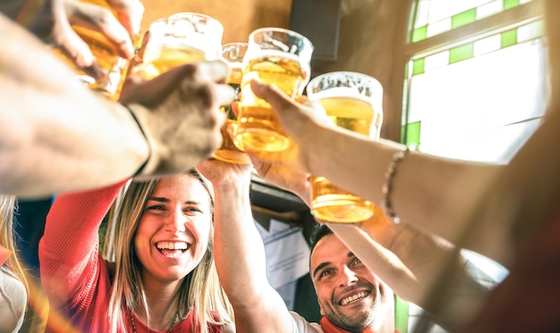 Amici che bevono e tostano birra al ristorante del bar della birreria?
