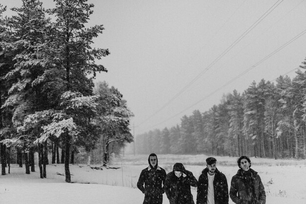 Amici che camminano in un bosco innevato