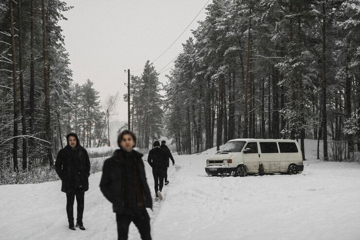 Foto amici che camminano in un bosco innevato