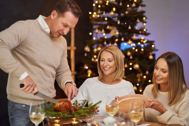 Amici che celebrano la festa di Natale tenendo il vino. Foto di alta qualità