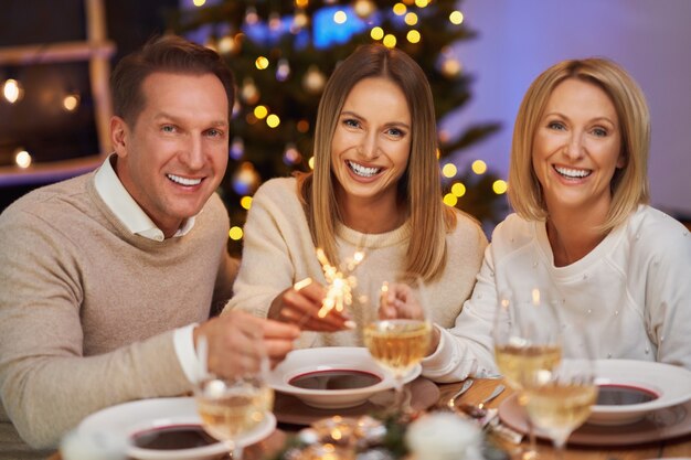 Amici che celebrano le stelle filanti della tenuta della festa di Natale. Foto di alta qualità