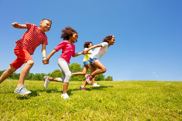 Amici che corrono nel parco contro il cielo in una giornata di sole