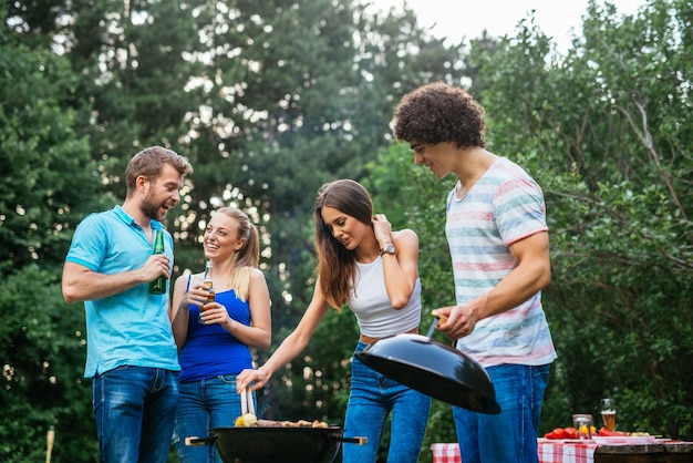 Amici che fanno barbecue insieme nella natura