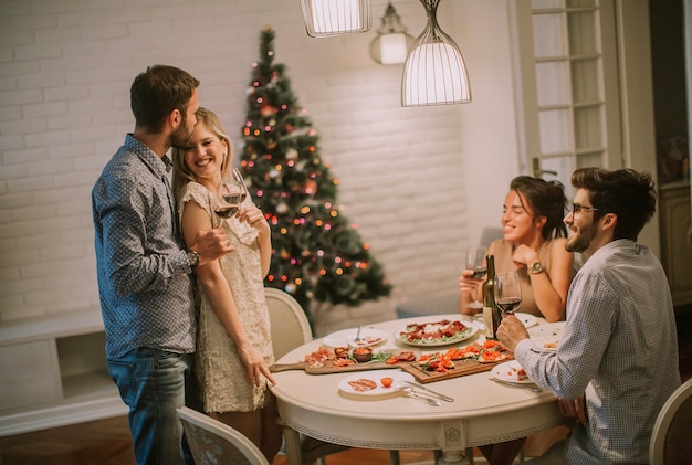 Amici che festeggiano il Natale o il capodanno a casa