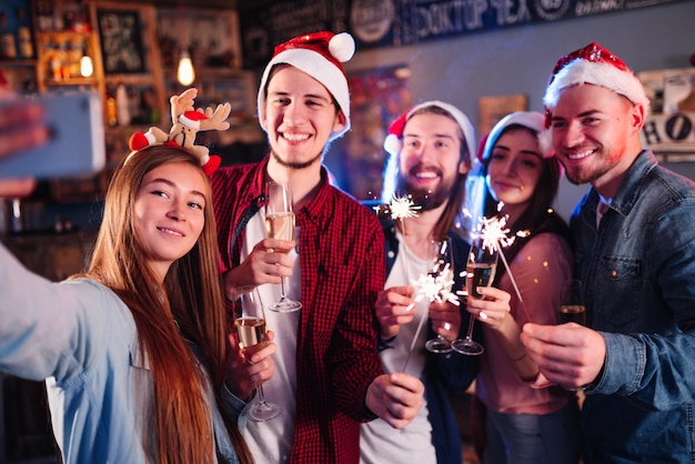 Amici che festeggiano insieme il nuovo anno Amici con bevande che si godono un cocktail party