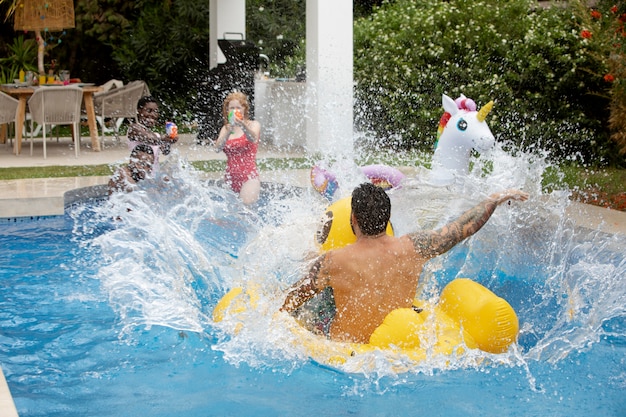 Amici che festeggiano una festa in piscina