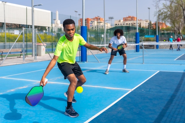 Amici che giocano a pickleball in un campo all'aperto in una giornata di sole