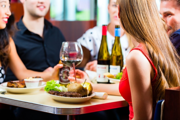 Amici che mangiano e bevono nella cena di fast food