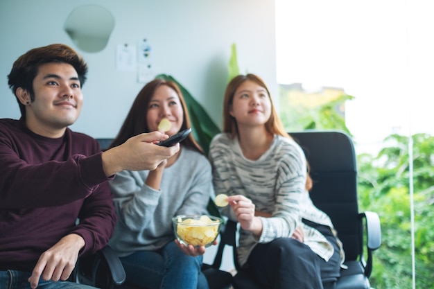 Amici che mangiano patatine mentre guardano la tv insieme