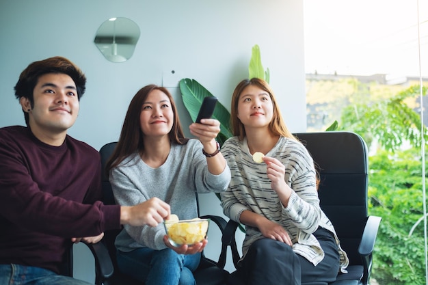 Amici che mangiano patatine mentre guardano la tv insieme