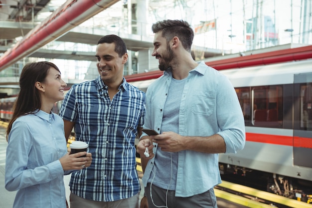 Amici che parlano alla stazione ferroviaria