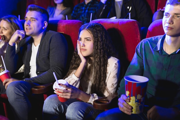 Amici che piangono guardando film tristi al cinema