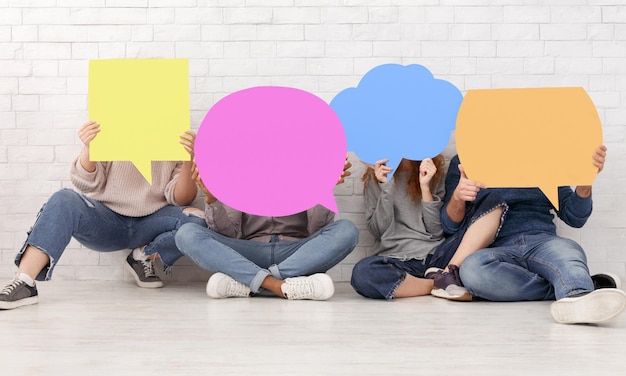 Amici che portano icone di bolle di discorso vuote che chiudono i volti