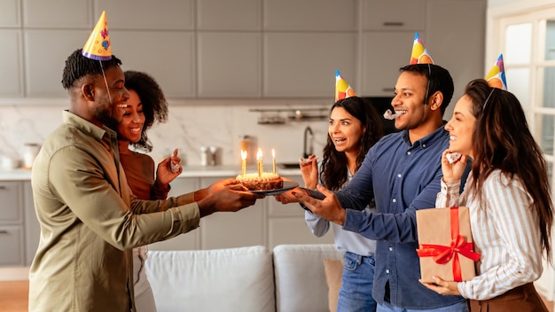 Amici che regalano una torta di compleanno a una donna