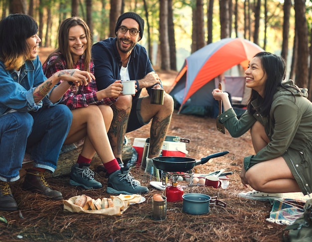 Amici che si accampano mangiando concetto dell&#39;alimento