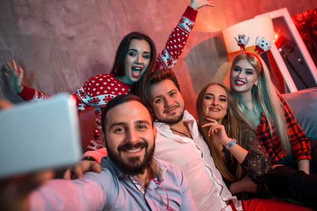 Amici che si fanno selfie mentre festeggiano il natale o il capodanno a casa