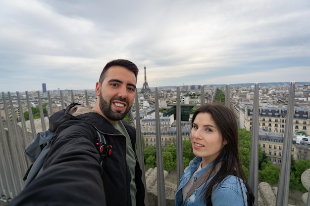 Amici che si fanno un selfie con la vista della torre eiffel sullo sfondo