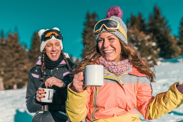 Amici che si godono la giornata invernale in montagna Bevendo caffè o tè all'aperto