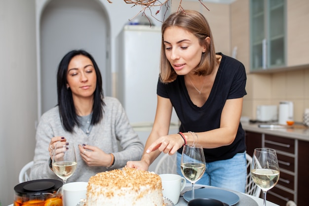 Amici che si incontrano con vino e torta