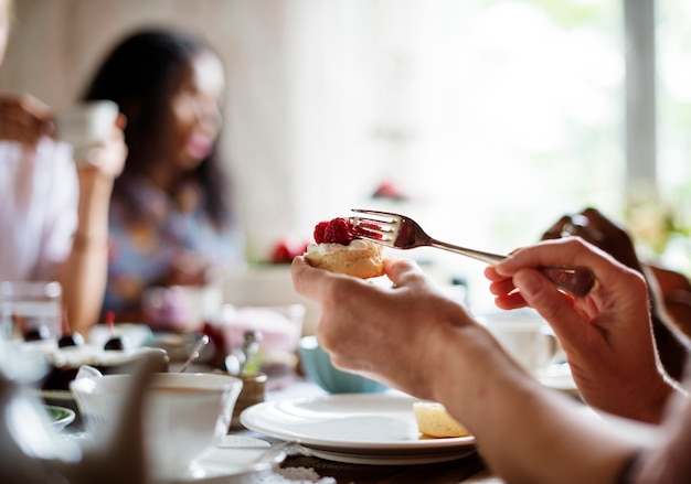 Amici che si riuniscono insieme su Tea Party Eating Cakes Enjoyment happiness