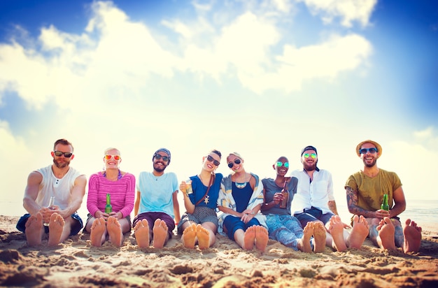 Amici che si siedono nella sabbia su una spiaggia