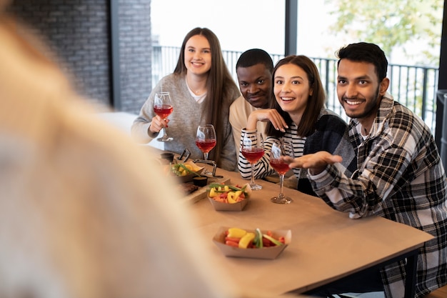 Amici che sorridono e tengono in mano un drink durante una riunione