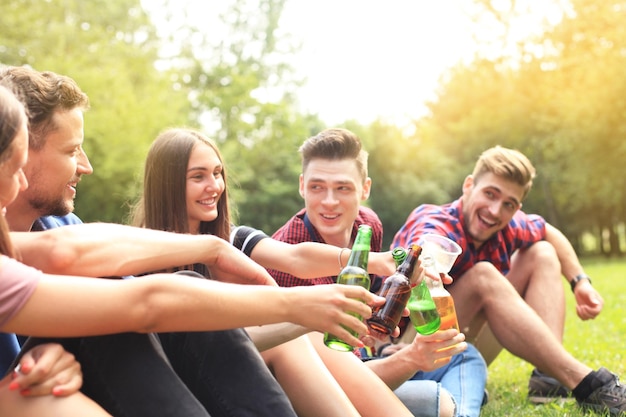 Amici che tostano birra al barbecue in natura.