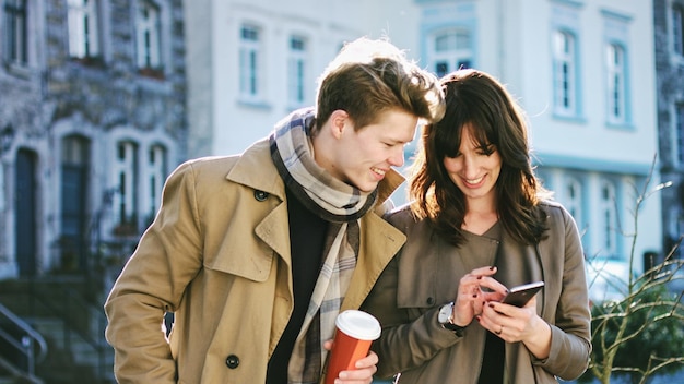 Amici che usano il cellulare in città