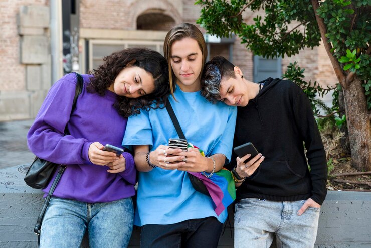 Foto amici che usano il cellulare mentre sono all'aperto per strada