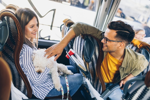 Amici che viaggiano in autobus, sorridono e parlano insieme.