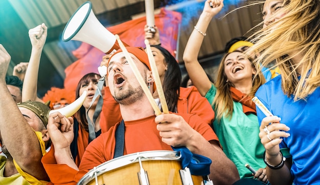 Amici dei tifosi che tifano e guardano la partita di calcio allo stadio internazionale